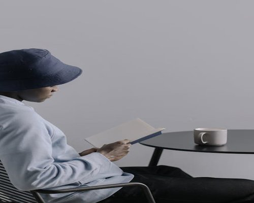 Persona relajada tomando café leyendo un libro físico